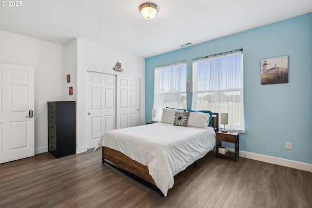 bedroom with dark wood-type flooring and a closet