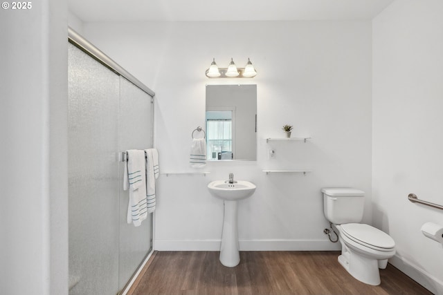 full bathroom with baseboards, a stall shower, wood finished floors, and toilet