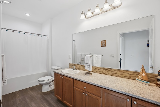 full bathroom featuring backsplash, hardwood / wood-style floors, vanity, shower / bath combination with curtain, and toilet