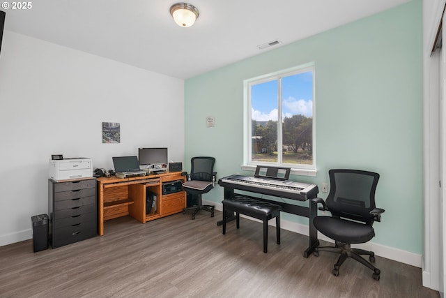 office featuring visible vents, baseboards, and wood finished floors