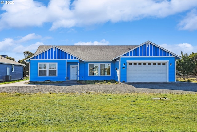 view of front of property with central AC unit, a garage, and a front yard