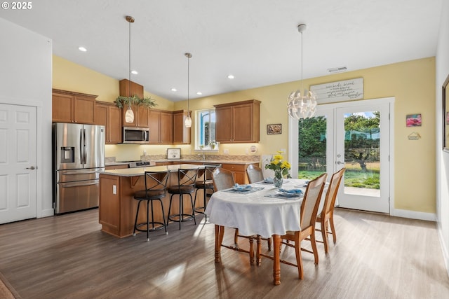 dining space with hardwood / wood-style flooring, lofted ceiling, and french doors