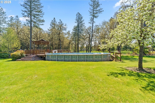 view of yard with a wooden deck, a gazebo, and an outdoor pool