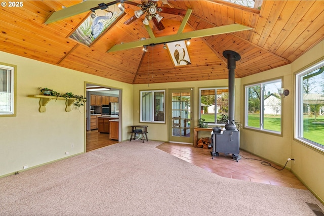 sunroom with a wood stove and visible vents