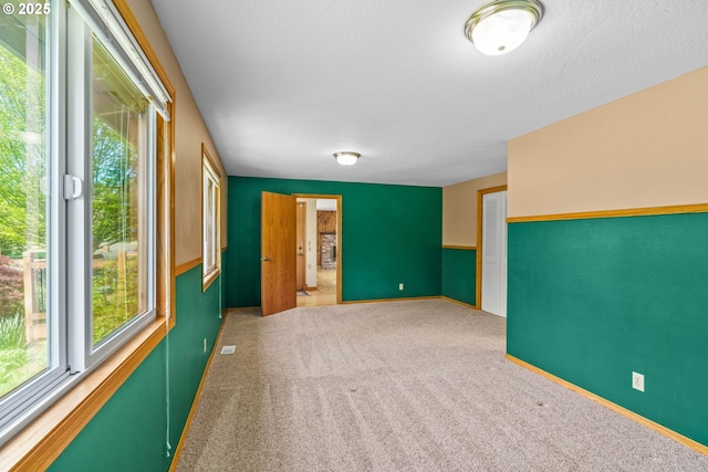 unfurnished room with carpet floors and baseboards