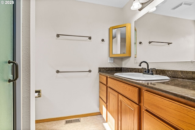 bathroom with baseboards, an enclosed shower, vanity, and visible vents
