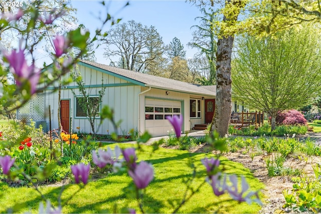 view of front of home featuring an attached garage, a wooden deck, board and batten siding, and a front lawn