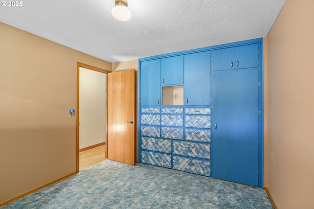 bedroom featuring baseboards, carpet floors, a textured ceiling, and a closet