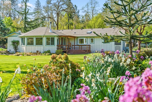 back of property featuring board and batten siding, a lawn, and a deck