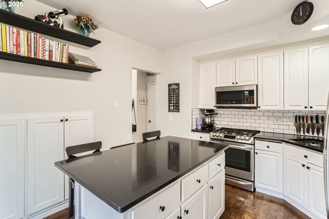 kitchen featuring backsplash, dark countertops, appliances with stainless steel finishes, open shelves, and white cabinets