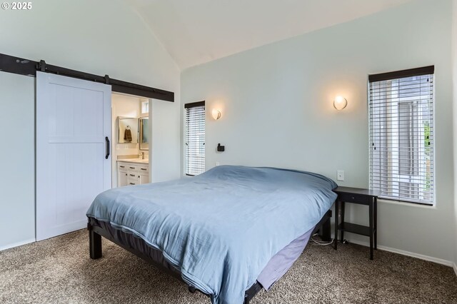 bedroom featuring carpet flooring, a barn door, ensuite bath, baseboards, and vaulted ceiling