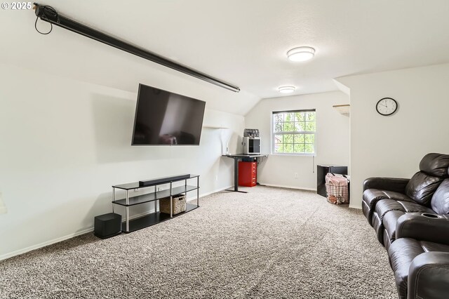 carpeted living room featuring baseboards and lofted ceiling
