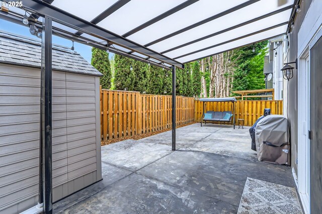 view of patio / terrace featuring a fenced backyard, an outbuilding, a pergola, and a grill