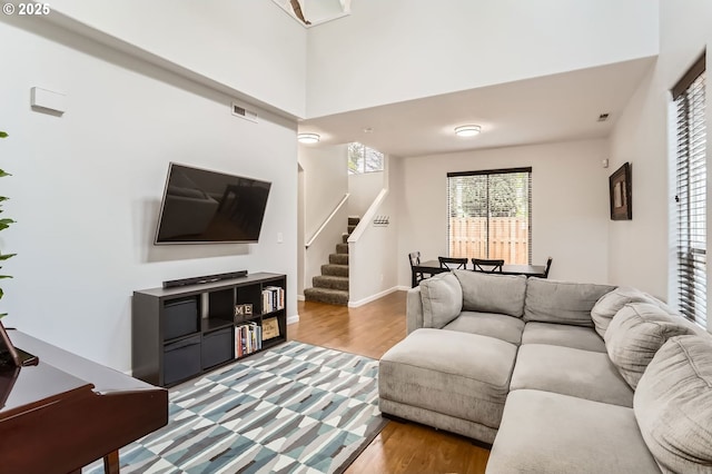 living room featuring visible vents, stairs, and wood finished floors