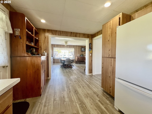 corridor with wood walls and light wood finished floors