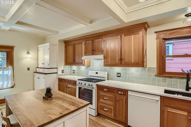 933 SE 31st Ave, Portland, OR 97214 - kitchen with white appliances, under cabinet range hood, brown cabinetry, tasteful backsplash, and beamed ceiling