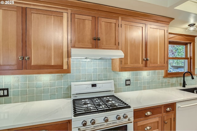 933 SE 31st Ave, Portland, OR 97214 - kitchen with white appliances, under cabinet range hood, tasteful backsplash, a sink, and light stone counters