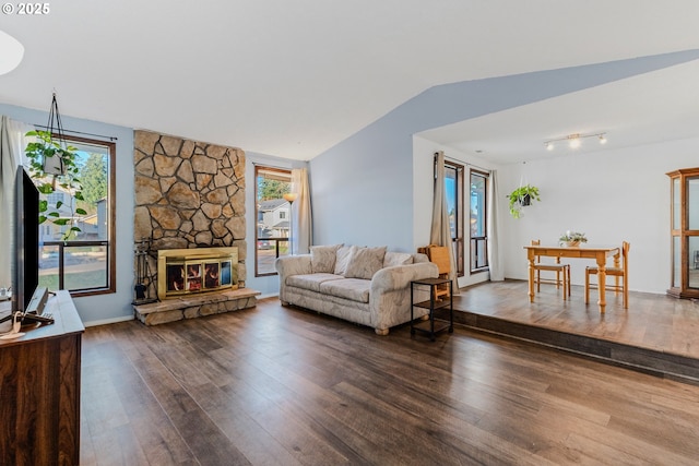 living room with dark hardwood / wood-style floors, a healthy amount of sunlight, and lofted ceiling