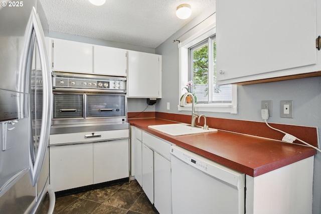 14996 SE Caruthers Ct, Portland, OR 97233 - kitchen with stainless steel appliances, white cabinets, a textured ceiling, and dark countertops
