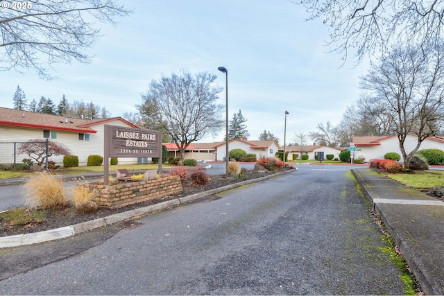 14996 SE Caruthers Ct, Portland, OR 97233 - view of asphalt road featuring street lights, a residential view, and curbs