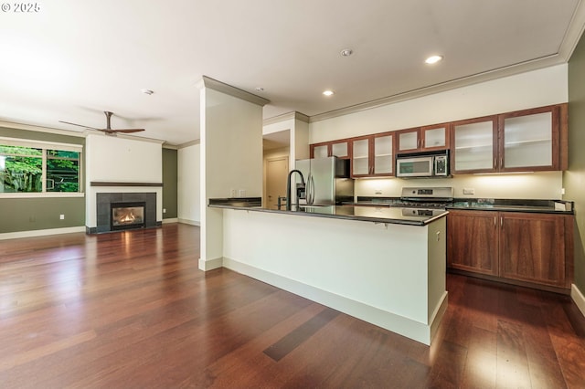 1951 NW Hoyt St, Portland, OR 97209 - kitchen with stainless steel appliances, dark countertops, dark wood finished floors, a peninsula, and a ceiling fan