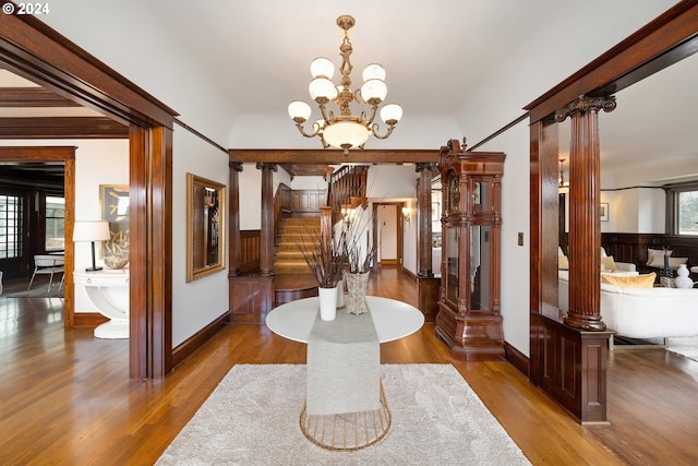 dining area featuring ornate columns, wood-type flooring, plenty of natural light, and a notable chandelier