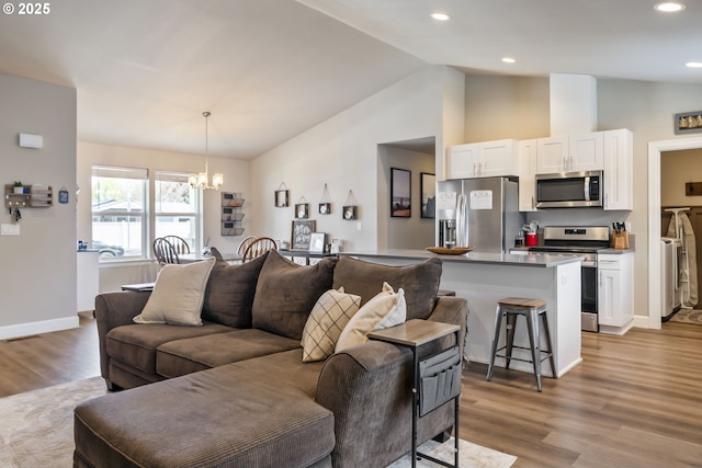 living area with wood finished floors, baseboards, high vaulted ceiling, an inviting chandelier, and recessed lighting