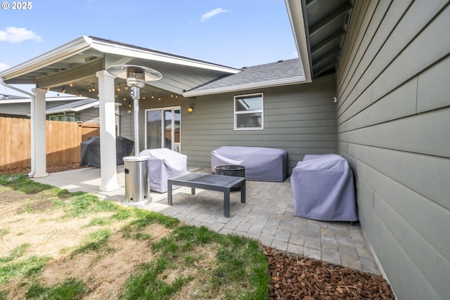 view of patio with fence and a grill