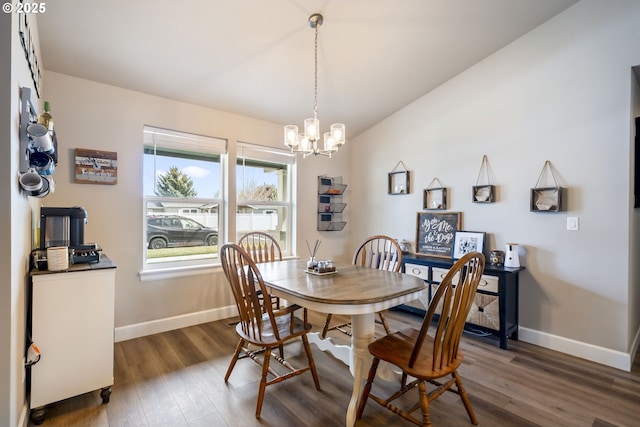 dining space featuring an inviting chandelier, baseboards, and dark wood-type flooring
