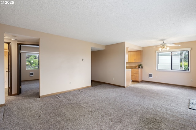 12110 SW King Arthur St, Portland, OR 97224 - unfurnished living room with light carpet, a textured ceiling, healthy amount of natural light, and a ceiling fan