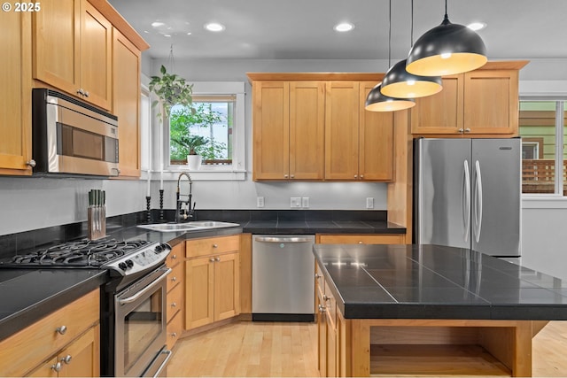 2733 NE 77th Pl, Portland, OR 97213 - kitchen with appliances with stainless steel finishes, light wood finished floors, recessed lighting, decorative light fixtures, and a center island
