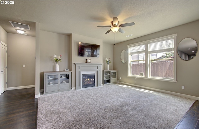 9817 NE 106th St, Vancouver, WA 98662 - unfurnished living room with dark wood-style floors, ceiling fan, a textured ceiling, and a glass covered fireplace
