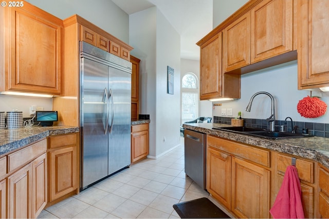 kitchen featuring stainless steel appliances, sink, and light tile patterned floors