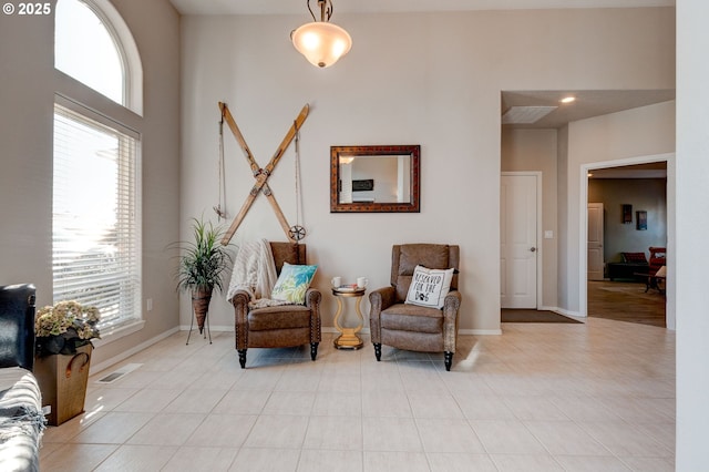 sitting room with light tile patterned floors and a high ceiling