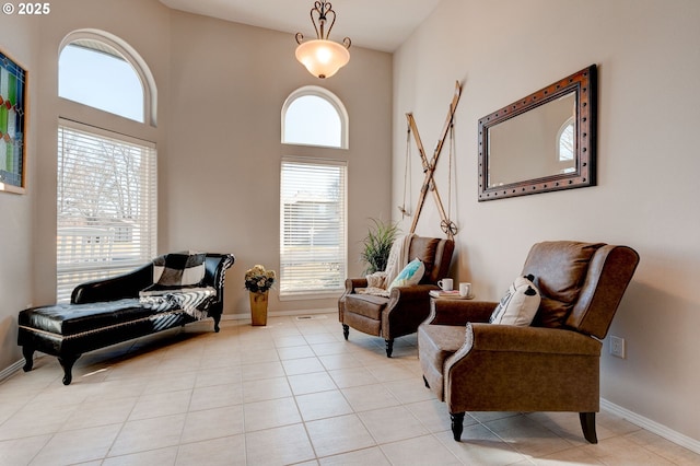 living area featuring light tile patterned flooring and a towering ceiling