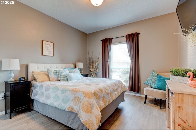 bedroom with hardwood / wood-style flooring and a textured ceiling