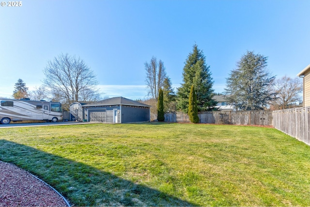 view of yard with a garage and an outbuilding