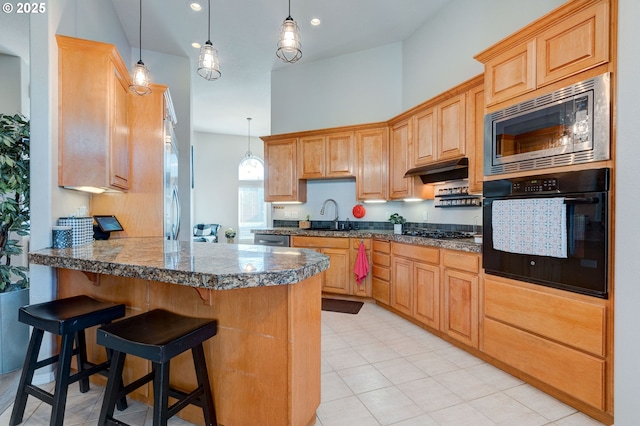 kitchen with pendant lighting, sink, black appliances, and kitchen peninsula