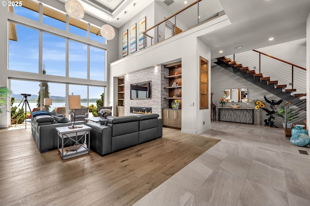 794 S A St, Washougal, WA 98671 - living room with a high ceiling, built in shelves, a stone fireplace, stairs, and recessed lighting