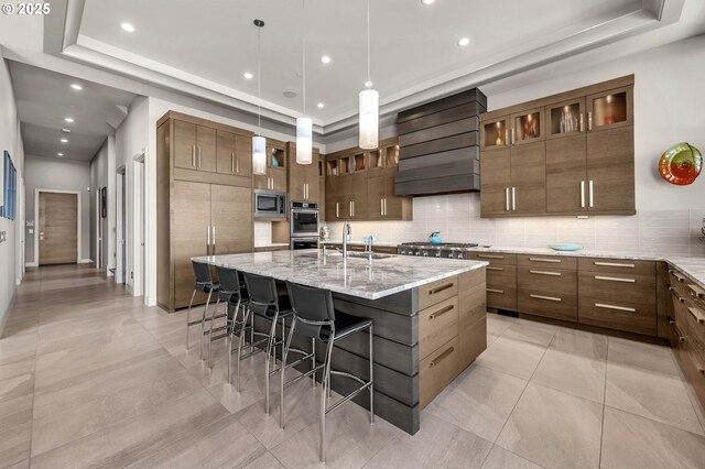 794 S A St, Washougal, WA 98671 - kitchen featuring premium range hood, appliances with stainless steel finishes, a raised ceiling, backsplash, and a kitchen bar