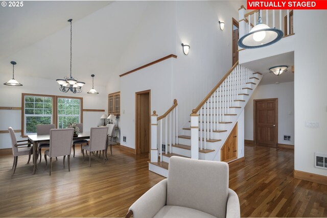 110 SW 61st St, South Beach, OR 97366 - dining space with high vaulted ceiling, stairs, wood finished floors, a chandelier, and baseboards