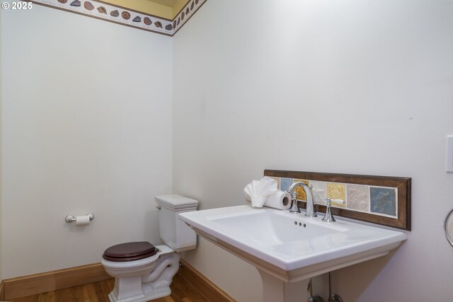 110 SW 61st St, South Beach, OR 97366 - bathroom featuring wood finished floors, toilet, and baseboards