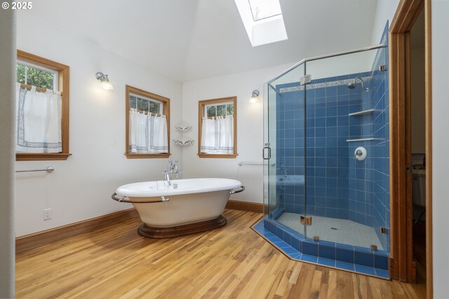 110 SW 61st St, South Beach, OR 97366 - full bathroom featuring a skylight, baseboards, a shower stall, wood finished floors, and a freestanding tub