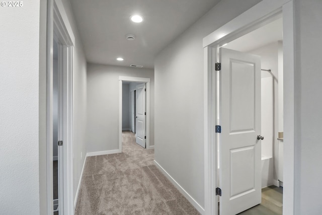 hallway featuring light colored carpet