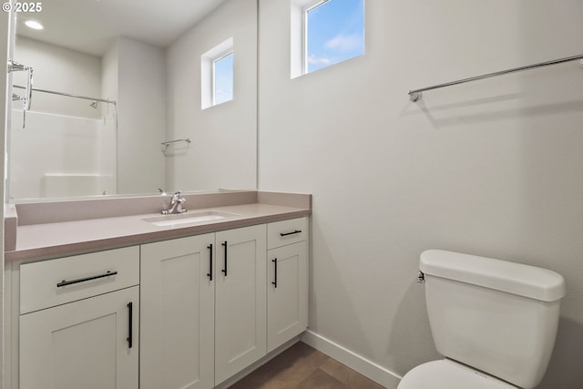 bathroom featuring vanity, toilet, and walk in shower