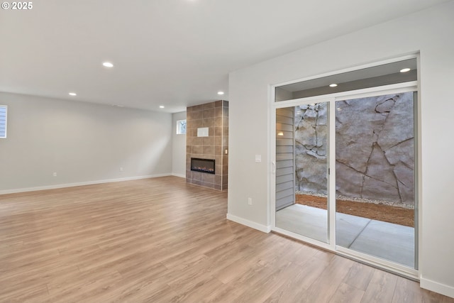 unfurnished living room with a fireplace and light wood-type flooring