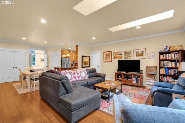 living area with baseboards, a skylight, light wood-style flooring, recessed lighting, and crown molding