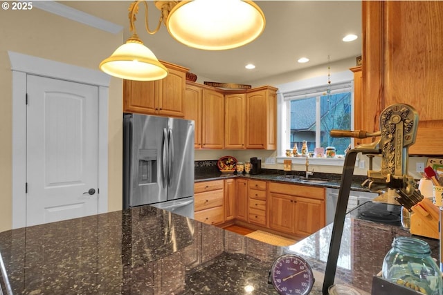 kitchen with a sink, recessed lighting, dark stone counters, and stainless steel fridge with ice dispenser