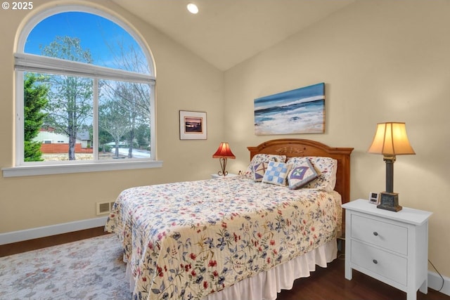 bedroom with dark wood-style floors, visible vents, baseboards, and vaulted ceiling