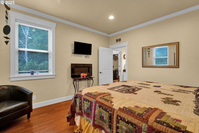 bedroom with visible vents, crown molding, baseboards, recessed lighting, and wood finished floors